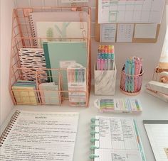 an organized desk with pens, notebooks and other office supplies on top of it