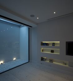 a living room filled with furniture and a flat screen tv mounted on a wall next to a window