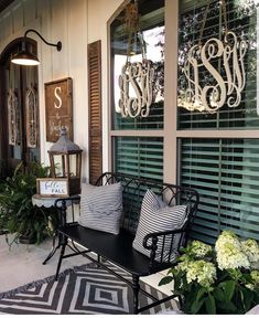 a black and white bench sitting in front of a window with shutters on it