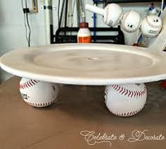 a cake plate with baseballs on it sitting on top of a table in a room