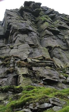 a very tall rock formation with moss growing on it