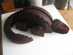 a chocolate cake sitting on top of a white cutting board