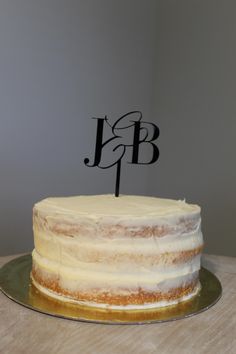 a cake with a monogram on top sitting on a table