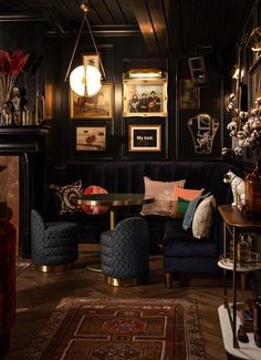 a living room filled with lots of furniture and pictures on the wall next to a fire place