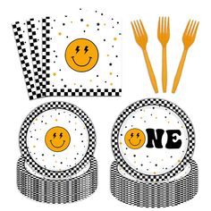 a table setting with plates, forks and napkins that have smiley faces on them