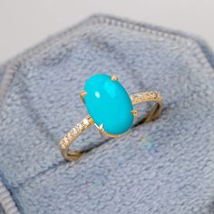 a turquoise ring sitting on top of a piece of cloth