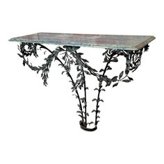 a metal table with leaves and vines on it's top, against a white background