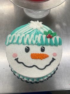 a frosted cupcake decorated with a snowman face on it's side