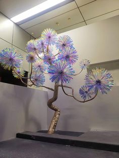 a metal sculpture with blue and purple flowers on it