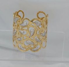 a yellow gold ring with diamonds on it's sides and an intricate design in the middle