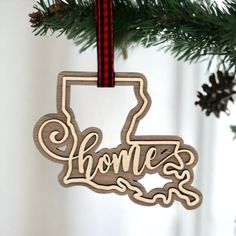 a wooden ornament hanging from a christmas tree with the word home on it