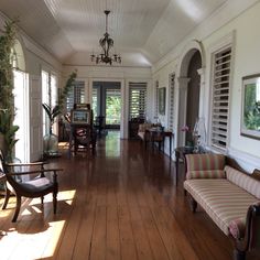 a large room with wooden floors and white walls, two couches on either side of the room