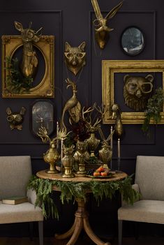 a dining room table with gold deer heads on the wall