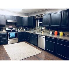 a kitchen with black cabinets and stainless steel appliances is pictured in this image from the front view