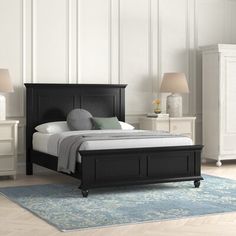 a bedroom with a bed, nightstands and two lamps on either side of the bed