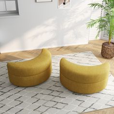 two yellow foot stools sitting on top of a rug next to a potted plant