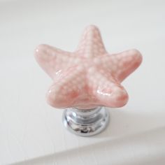 a pink starfish is sitting on the edge of a bathroom sink