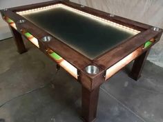 a pool table that has some lights on top of it and is made out of wood