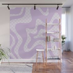 a purple and white wall mural in a living room with wooden floors, a chair and bookshelf