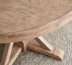 a round wooden table sitting on top of a carpeted floor