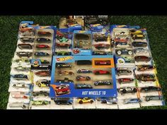 many hot wheels cars are on display in the grass