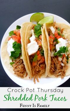 three shredded pork tacos on a white plate