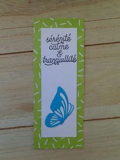 a blue butterfly on a green and white bookmark that says serenie coulee et tranquillite