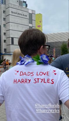 a man wearing a t - shirt that says dads love harry styles on his back