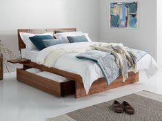 a bed sitting on top of a white floor next to a wooden dresser and foot board