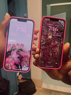 two people holding up their cell phones with flowers on them