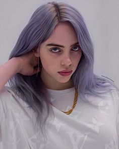 a woman with purple hair wearing a white t - shirt and gold necklace, looking at the camera