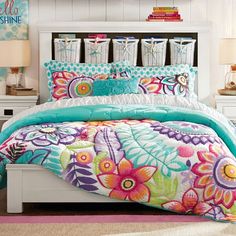 a bed with colorful comforters and pillows