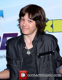 a man in black jacket standing next to a table