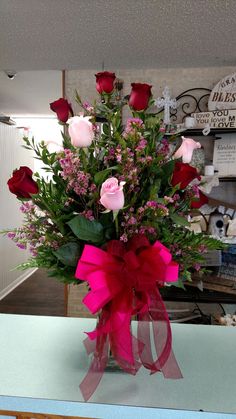 a vase filled with lots of pink and red flowers