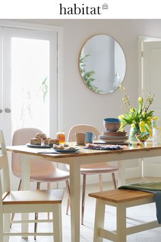 a table with plates and bowls on it in front of a mirror that says habitat