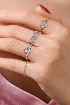 a woman's hand with three different rings on her finger and one ring in the middle