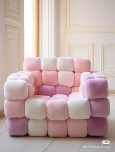 a pink and white chair sitting on top of a hard wood floor