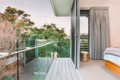 a bedroom with a balcony overlooking the trees