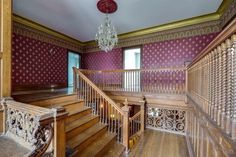 an ornately decorated staircase with chandelier and wooden handrails in a house