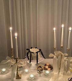 a table topped with lots of white candles