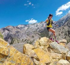 a woman running on rocks in the mountains