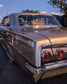 an old car parked on the side of the road with a crown on it's hood