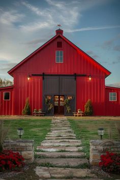 a red barn with steps leading up to the front door and entry way that leads into the yard