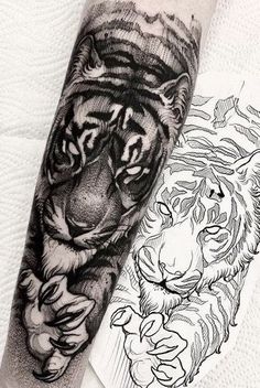 a black and white tiger tattoo on the left arm with another tiger in the background