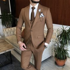 a man in a suit and tie standing next to a couch