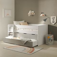 a child's bedroom with white furniture and decor