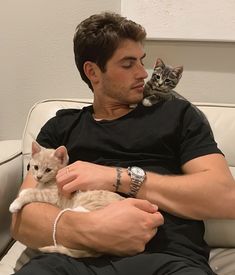 a man sitting on a couch holding a cat