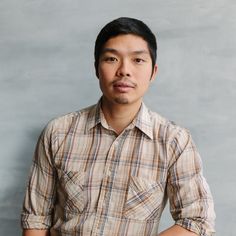 a man standing in front of a gray wall