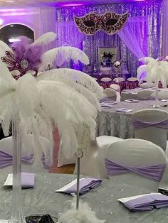 a room filled with lots of tables covered in white and purple decorations