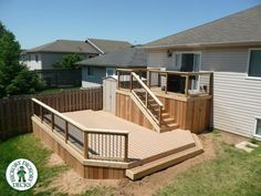 a wooden deck with steps and railings next to a fenced in backyard area